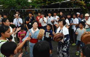 研修で来島した鹿大生も交えてにぎやかに歌い踊った佐仁の八月踊り＝７日、奄美市笠利町